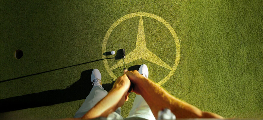 Golfrasen mit Mercedes-Benz Logo Golfrasen mit Mercedes-Benz Logo und Golfschläger, der Ball ins Loch spielt
